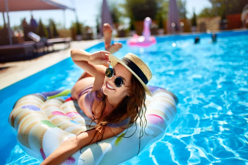 woman with hat and sunglasses at pool